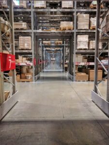 Shelved furniture and labeled boxes inside a clean, climate-controlled storage unit.
